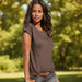 Woman wearing a brown t-shirt with a blurred beach background