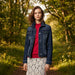 Woman wearing a denim jacket over a red top with a white background
