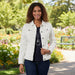 Woman wearing a white denim jacket on a plain background